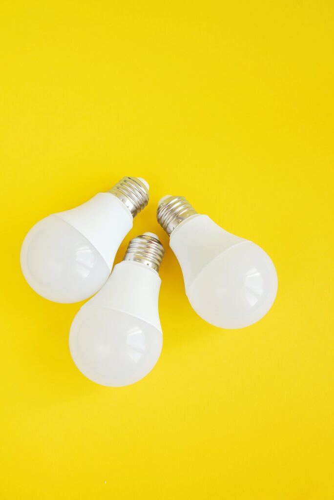 Three LED light bulbs on yellow background. energy saving concept.